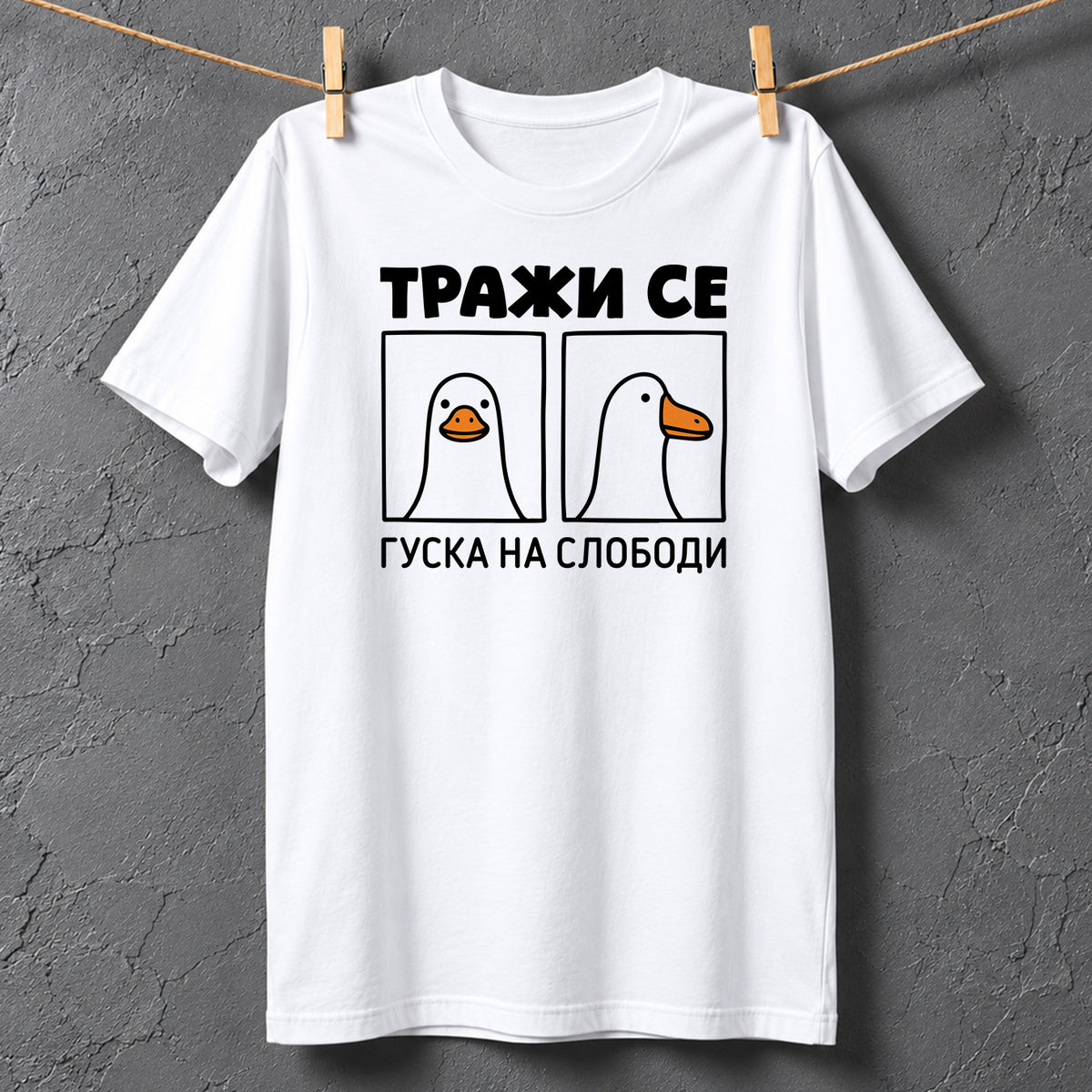 Bela majica sa crnim natpisom Traži se – Guska na slobodi i duhovitom ilustracijom guske iz dva ugla, smešna majica sa štampom